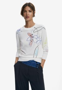 Maglione bianco lavorato a maglia con ricami floreali multicolori in rosa, blu e giallo. Presenta un classico scollo a girocollo e polsini a costine.