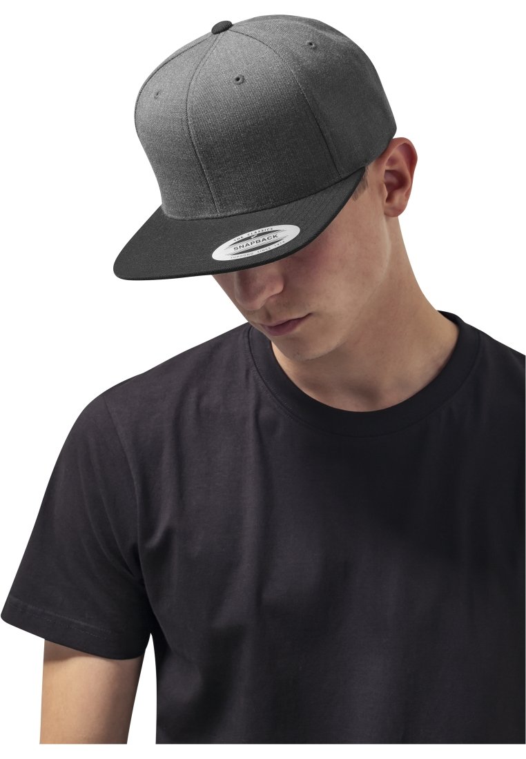 Szürke snapback sapka lapos karimával, texturált anyagból készült. Az elején logó példa látható, és egy sima fekete pólóval van viselve.