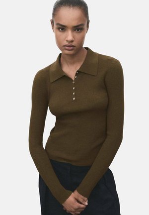 Bruine geribde lange mouw polo met een kraag en decoratieve knopen. De stof heeft een gestructureerde afwerking en sluit nauw aan op het lichaam.