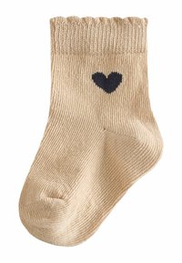Beige knitted sock with a ribbed cuff and a navy heart design. The texture is soft and the shape is standard for children's socks.