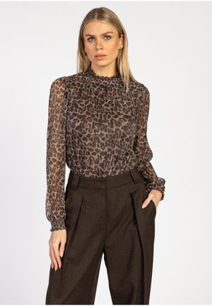 Doorzichtige blouse met een luipaardpatroon, hoge halslijn en ruches op de schouders, gecombineerd met hoog getailleerde, donkerbruine broek.
