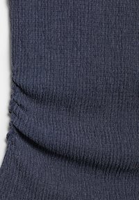 Tmavě modrá texturovaná látka se shromážděným elastickým detailem vytvářejícím horizontální záhyby a mírně žebrovaný vzor.