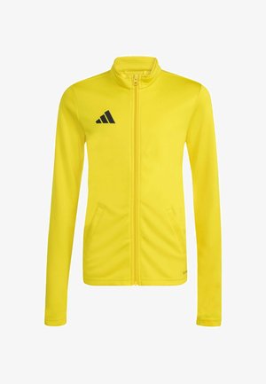 Žltá športová bunda na celé zipsovanie s dlhými rukávmi, vysokým golierom, bočnými vreckami a čiernym logom Adidas na ľavej strane hrudníka.