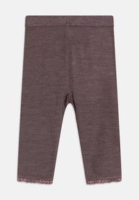 Leggings maronii dintr-un material moale, texturat. Prezintă un tiv din dantelă la tiv și o talie strânsă. Croiul se extinde până la jumătatea gambei.
