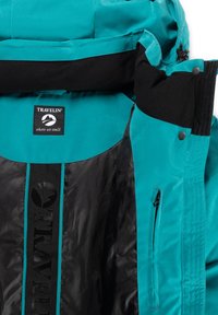 Cyan en zwarte buitenjas met ritszak, drukknoopsluiting en een "Travelin' where we walk" logo patch binnen de kraag.