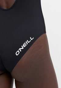 Černé plavkové spodky vyrobené z elastického materiálu. Na boku je bílé logo "O'NEILL", mají hladkou strukturu a přiléhavý střih.