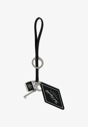 Porte-clés noir avec une lanière en cuir, quincaillerie argentée, un charme en forme de clé et une étiquette rectangulaire avec du texte blanc sur fond noir.