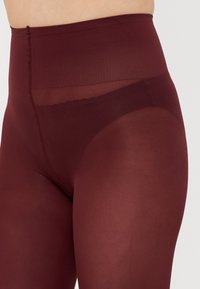 Burgundy högmidjade strumpbyxor med en genomskinlig panel upptill, med en slät textur och ett mjukt, flexibelt material för komfort.