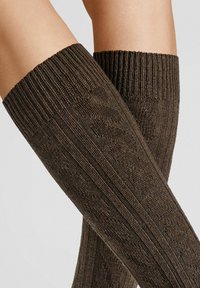 Braune knielange Socken mit gerippten Bündchen, die ein strukturiertes Muster und eine glatte Oberfläche aufweisen und somit ihr gestricktes Design hervorheben.