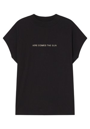T-shirt en coton noir à manches courtes avec un texte blanc disant "HERE COMES THE SUN" dans une police simple, centré sur la poitrine.