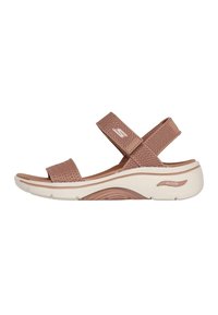 Sandalias de malla marrones con doble correa y suela blanca acolchada que presenta la tecnología ArchFit. Parte superior texturizada notable y diseño curvado.