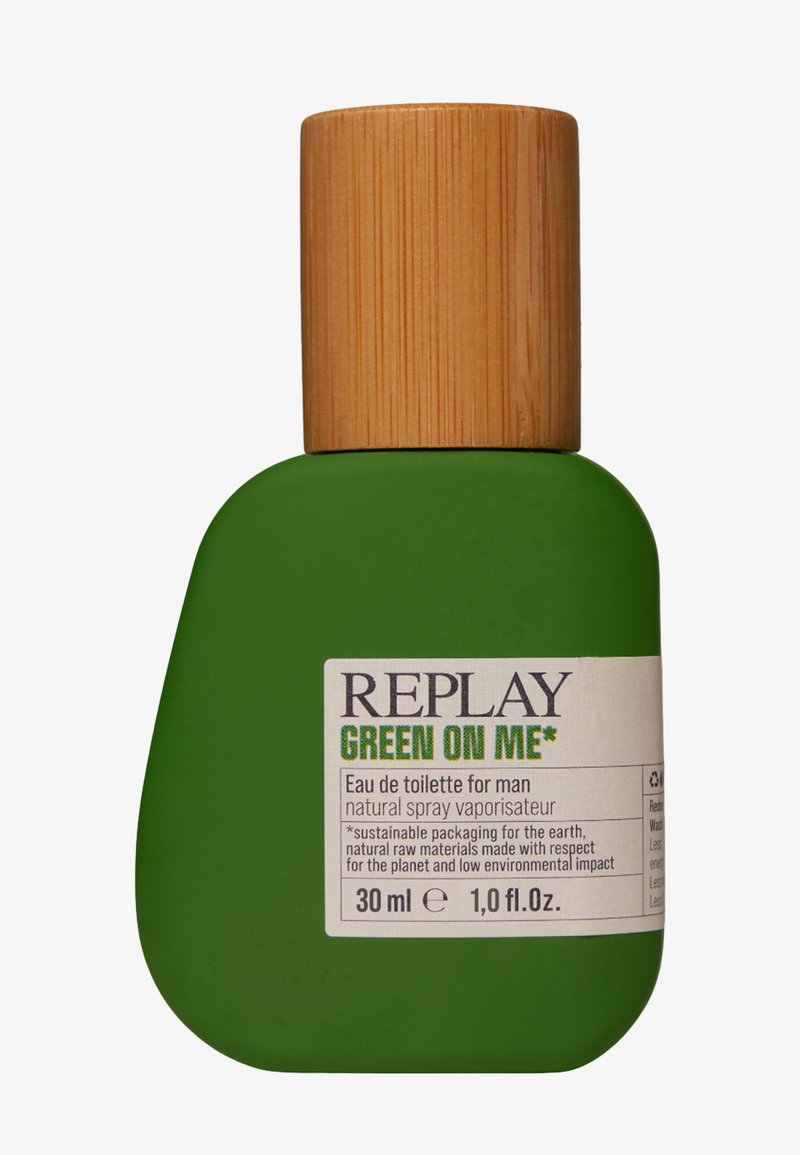 Flacon de parfum vert avec une forme arrondie, finition mate et bouchon en bois ; l'étiquette présente les détails du produit en texte noir et vert.