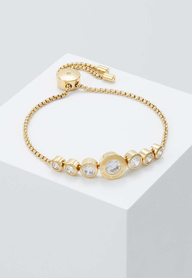 Goldener Armreif mit Kettendesign, verziert mit runden klaren Kristallen und einem runden Verschluss, beschriftet mit "Michael Kors".