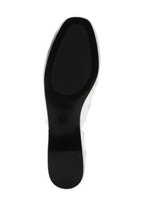 Black rubber sole with textured grip pattern, featuring a smooth white upper section and embossed logo detail. Classic shoe design.