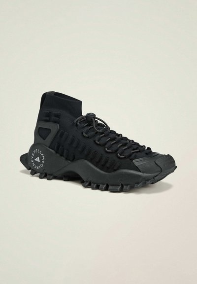 Sneaker alta nera in tessuto texture, con lacci sicuri, suola in gomma e un motivo di battistrada evidente; presenta un dettaglio del logo sul tallone.