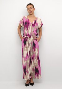 Mono estampado en rosa y beige con escote en V, mangas cortas y cinturón ajustable. Presenta un corte holgado y pantalones de pierna ancha.
