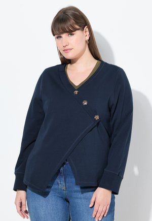 Marineblauwe sweatshirt met een v-hals en olijfgroen afwerking, voorzien van een diagonale sluiting met drie decoratieve knopen en lange mouwen.
