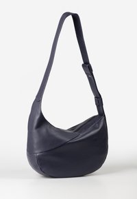 Borsa a spalla in pelle blu navy con design curvo, texture liscia, tracolla ampia e chiusura superiore a zip. Presenta cuciture a contrasto e una base arrotondata.