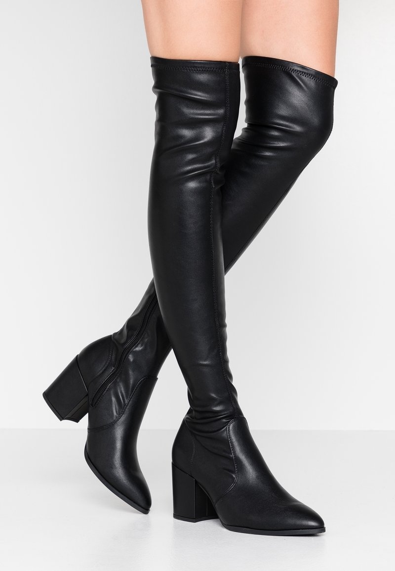 Black leather thigh-high boots with a pointed toe and block heel, featuring a smooth texture and a zip closure along the side.
