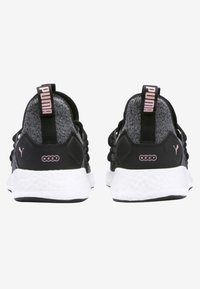 Chaussures de sport noires et grises avec une tige en maille, semelle intermédiaire blanche et accents roses. Comprend une sangle de traction et un talon texturé pour un soutien optimal.