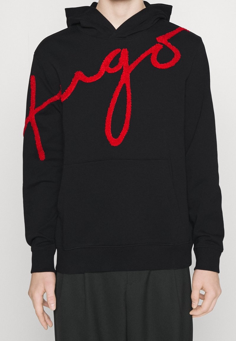 Schwarzer Kapuzenpullover mit einem großen, strukturierten, roten gestickten Logo. Mit Kängurutasche sowie gerippten Bündchen und Saum.