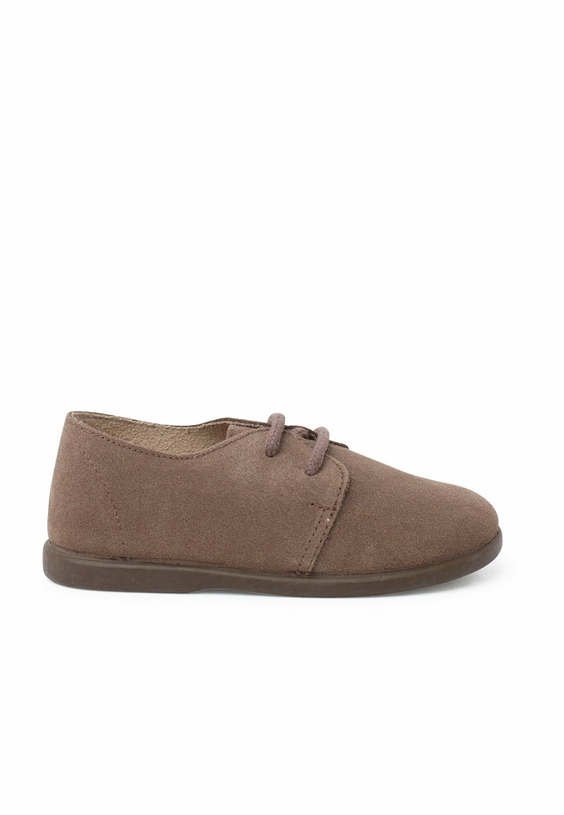 Scarpa in suede marrone con profilo basso, punta rotonda, design con lacci e suola in gomma flessibile. Texture liscia e dettagli di cucitura minimi.