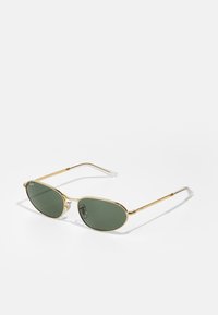 Gafas de sol con marco de metal dorado y lentes verdes, de forma ovalada, con varillas delgadas y puntas transparentes. Incluye un sutil logo en el lente izquierdo.