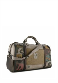 Große Reisetasche mit einem beigen Kunstlederkörper und bunten abstrakten Mustern, zwei Griffen und einem verstellbaren Schultergurt.