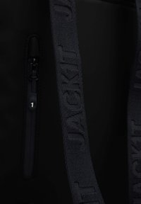 Borsa nera con tasca con zip e nome del marchio in rilievo sulla tracolla. Texture liscia con un design semplice e moderno.