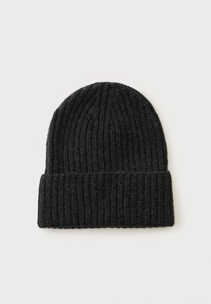 Bonnet noir en tricot avec un revers plié présenté sur un fond clair uni.