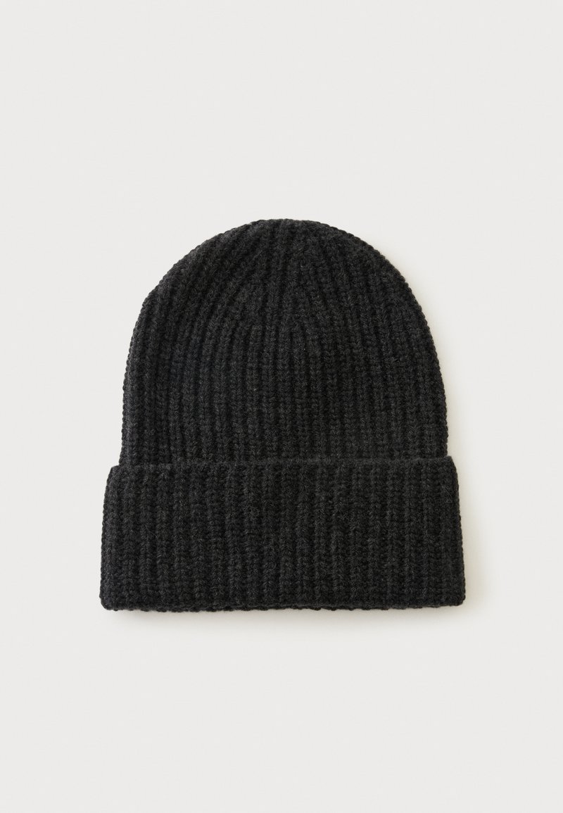 Bonnet noir en tricot avec un revers plié présenté sur un fond clair uni.