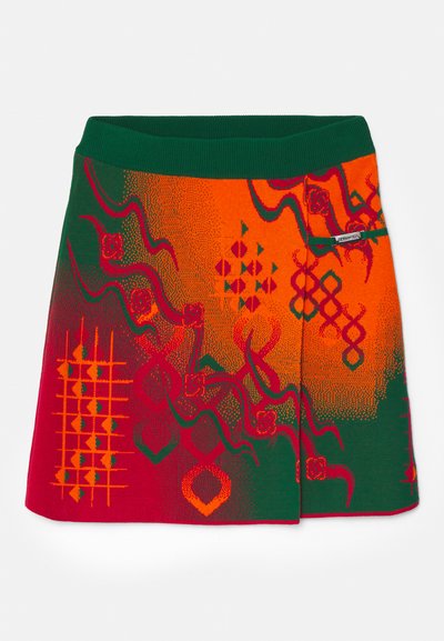 Kötött szoknya zöld derékrésszel és élénk piros és narancs mintákkal, geometriai formákkal és texturált részletekkel.