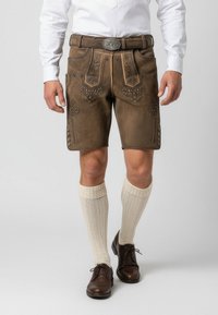 Hnědé kožené lederhosen se zdobnou výšivkou, doplněné krémovými ponožkami ke kolenům a hnědými šněrovacími botami.