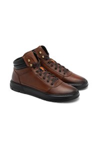 Brązowe skórzane buty typu high-top z czarnymi akcentami, metalowymi oczkami i teksturowaną powierzchnią. Posiada płaskie sznurówki i solidną gumową podeszwę.