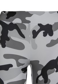 Magas derekú leggings terepszínű mintával, szürke és fekete árnyalatokkal, sima, rugalmas anyagból készültek.