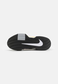 Suola di scarpa Nike in gomma nera con motivo a zigzag, dotata di un logo swoosh bianco e accenti grigi. Superficie testurizzata per una migliore aderenza.