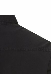 Schwarzes Hemd mit einer sanften Textur, ausgestattet mit einem spitzen Kragen und subtiler Naht entlang der Schulternaht. Die Rückansicht zeigt ein schlichtes Design.