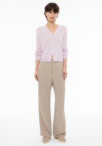 Light pink cardigan with button closure, paired with beige wide-leg trousers. Soft texture, relaxed fit, and minimalistic design.