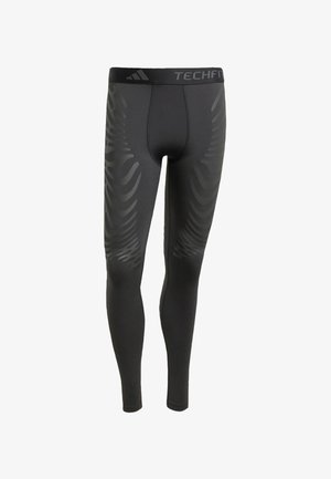 Crne atletske tajice glatke teksture, s toniranim valovitim uzorkom sa strane i brendiranim pojasom označenim "TECHFIT."