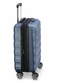 Maleta rígida en azul marino mate con acabado texturizado. Cuenta con cremallera negra, doble rueda y asa extensible para una fácil movilidad.