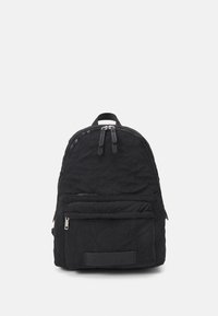 Czarny pikowany plecak z główną komorą zamykaną na zamek, przednią kieszenią i uchwytem do noszenia na górze. Teksturowany materiał z naszywką logo.