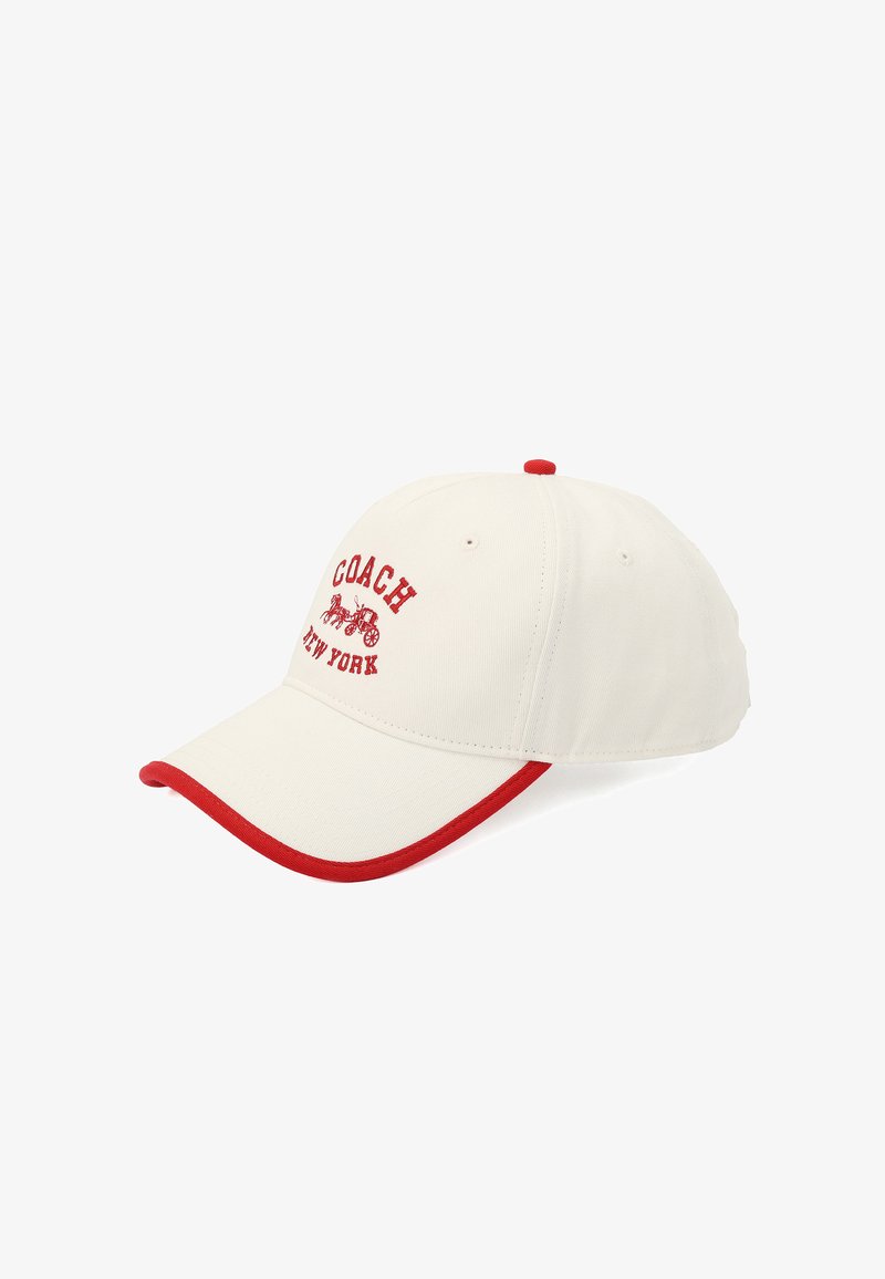 Crèmekleurige baseballpet met rode accenten, voorzien van "COACH" en "NEW YORK" in het rood geborduurd. Gemaakt van stof met een gebogen klep.