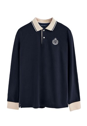 Camisa polo de manga larga azul marino con un collar beige, que presenta un logo en el pecho y acentos a rayas en contraste en el cuello y los puños.