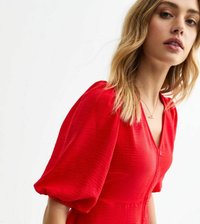 Robe rouge texturée avec des manches courtes bouffantes et un décolleté en V profond, dotée d'une fermeture à boutons à l'avant et d'une taille cintrée.