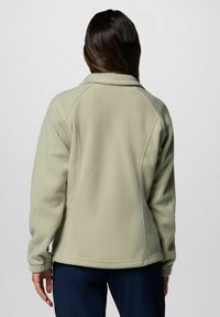 Fleecejacke in hellgrün mit Stehkragen, Raglanärmeln und einer glatten Textur mit Nähdetails entlang der Nähte.