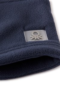 Bonnet en polaire bleu marine avec une texture douce, doté d'un patch en caoutchouc transparent avec un design abstrait à l'avant.