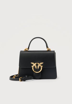 Czarna skórzana torebka z górnym uchwytem, regulowanym paskiem na ramię oraz złotym zapięciem w kształcie ptaka na przedniej klapie.