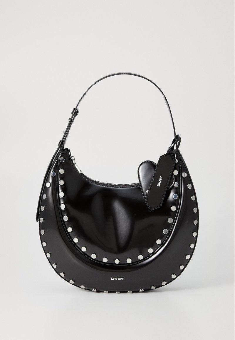 Sac à main en cuir verni noir avec une forme incurvée, des clous argentés le long du bord, et une fermeture éclair. Comprend une étiquette détachable avec le logo.