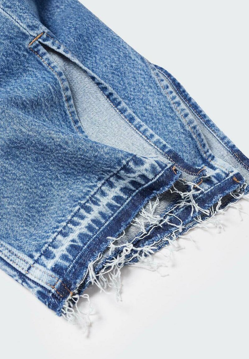 Shorts en denim bleu effilochés avec des fils blancs visibles et une poche latérale sur un fond blanc.