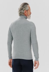 Szary sweter dzianinowy z wysokim kołnierzem i długimi rękawami. Materiał wydaje się miękki, z prążkowanymi mankietami i dołem. Wyświetlony od tyłu.